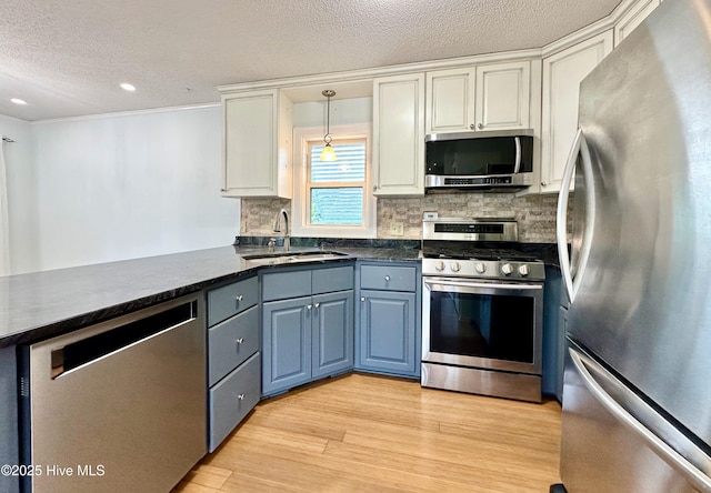 122 Ethel Dr, Emerald Isle, NC 28594 - kitchen with appliances with stainless steel finishes, a textured ceiling, backsplash, white cabinets, and light wood finished floors