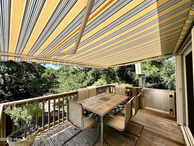 122 Ethel Dr, Emerald Isle, NC 28594 - wooden terrace with outdoor dining space, view of wooded area, and a baseboard radiator