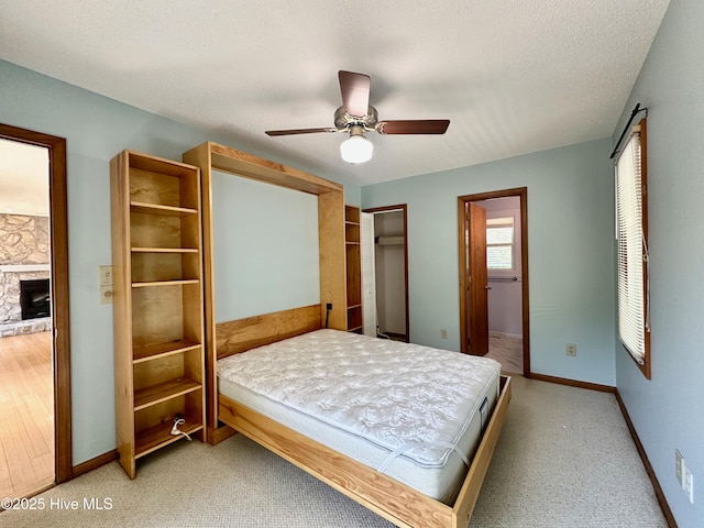 122 Ethel Dr, Emerald Isle, NC 28594 - bedroom with a stone fireplace, a ceiling fan, and light colored carpet