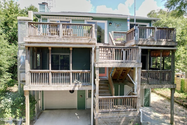 122 Ethel Dr, Emerald Isle, NC 28594 - view of front facade featuring a balcony, stairs, a garage, a deck, and a sunroom