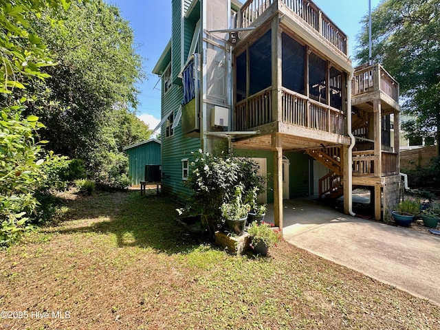122 Ethel Dr, Emerald Isle, NC 28594 - back of house with a sunroom, stairway, a balcony, a carport, and concrete driveway