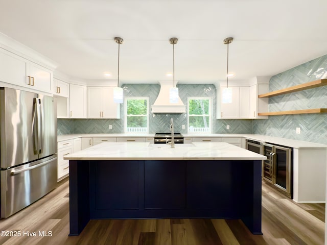 9891 Red Fox, Winnabow, NC 28479 - kitchen with appliances with stainless steel finishes, premium range hood, wine cooler, backsplash, and white cabinetry