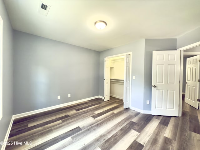 9891 Red Fox, Winnabow, NC 28479 - unfurnished bedroom with dark wood-style flooring and a closet