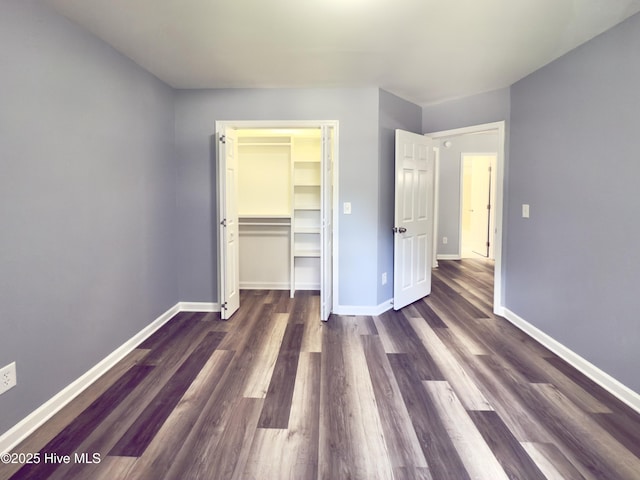 9891 Red Fox, Winnabow, NC 28479 - unfurnished bedroom with wood finished floors, a closet, and a walk in closet