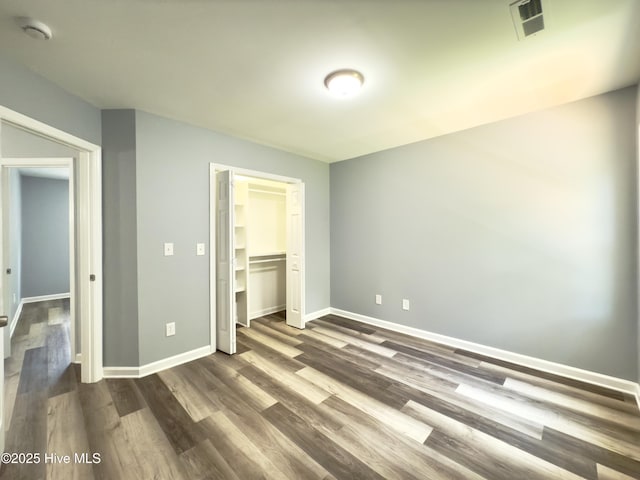9891 Red Fox, Winnabow, NC 28479 - unfurnished bedroom with dark wood-style floors and a closet