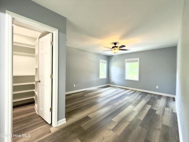 9891 Red Fox, Winnabow, NC 28479 - unfurnished bedroom with a spacious closet, dark wood-type flooring, a closet, and ceiling fan