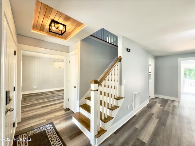 9891 Red Fox, Winnabow, NC 28479 - staircase featuring wood finished floors, a chandelier, and a tray ceiling