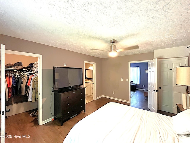 735 N Bennett St Unit A, Southern Pines, NC 28387 - bedroom with a walk in closet, wood finished floors, a closet, a textured ceiling, and ensuite bathroom