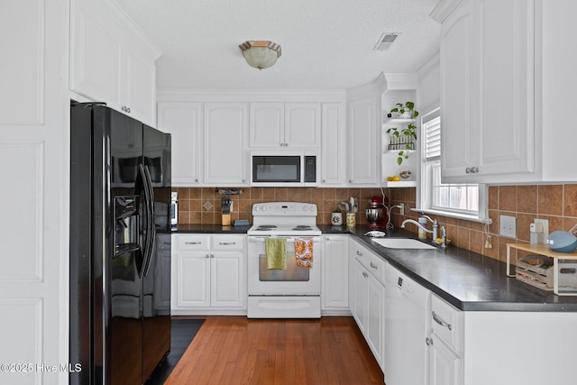 2827 Sapling Cir, Wilmington, NC 28411 - kitchen with white appliances, dark countertops, white cabinets, dark wood-type flooring, and open shelves