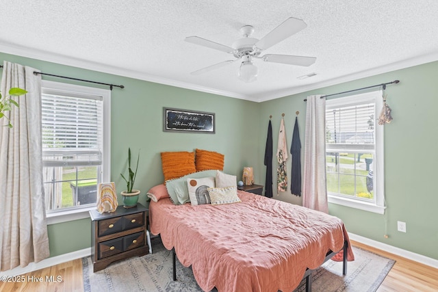 2827 Sapling Cir, Wilmington, NC 28411 - bedroom with crown molding, wood finished floors, a textured ceiling, and ceiling fan