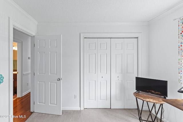 2827 Sapling Cir, Wilmington, NC 28411 - bedroom with a closet, crown molding, a textured ceiling, and light carpet