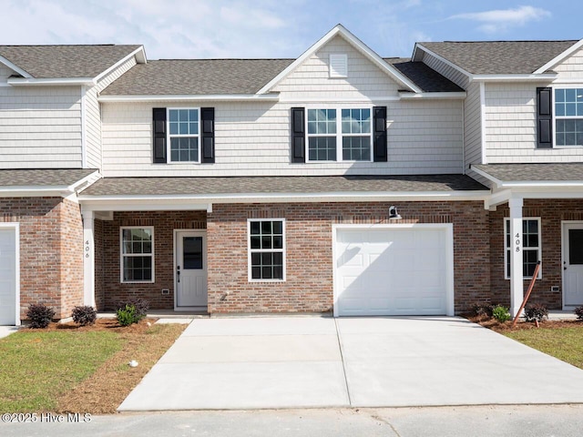 208 Triton Ln, Surf City, NC 28445 - townhome / multi-family property with an attached garage, concrete driveway, brick siding, and roof with shingles