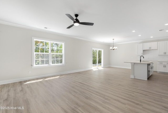 208 Triton Ln, Surf City, NC 28445 - unfurnished living room with crown molding, a chandelier, light wood finished floors, a ceiling fan, and recessed lighting