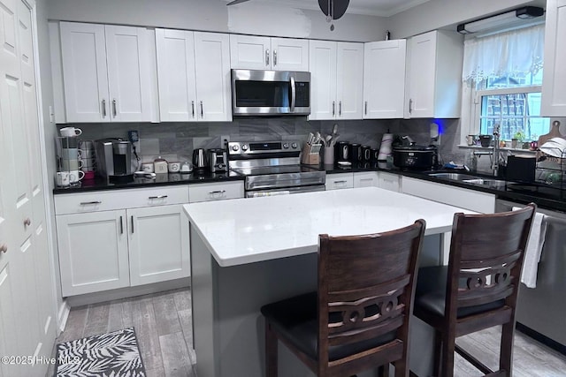 2903 Cedar Creek Rd Apt B, Greenville, NC 27834 - kitchen with appliances with stainless steel finishes, light wood-type flooring, a kitchen breakfast bar, backsplash, and ornamental molding