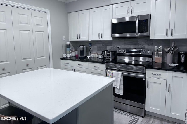 2903 Cedar Creek Rd Apt B, Greenville, NC 27834 - kitchen with stainless steel appliances, backsplash, white cabinetry, and a center island