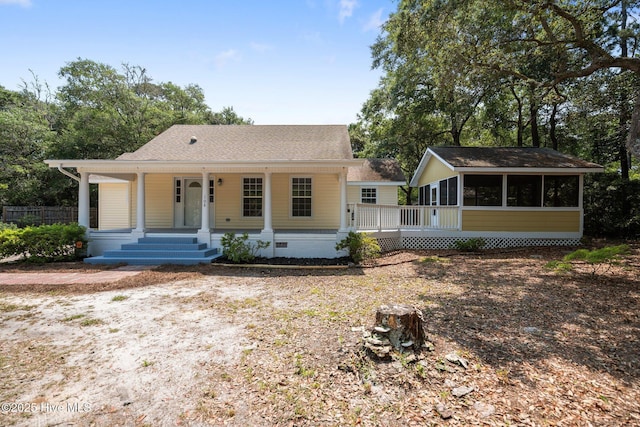 108 NW 29th St, Oak Island, NC 28465 - view of front facade with a sunroom, covered porch, roof with shingles, and crawl space
