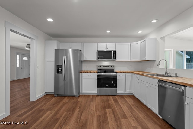 108 NW 29th St, Oak Island, NC 28465 - kitchen with stainless steel appliances, wood counters, dark wood-style floors, white cabinets, and recessed lighting