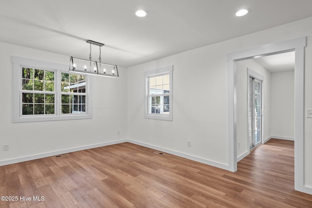 108 NW 29th St, Oak Island, NC 28465 - empty room with light wood-type flooring, recessed lighting, and a chandelier