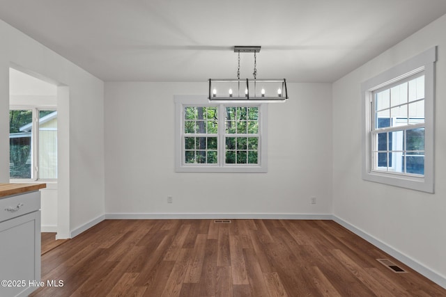 108 NW 29th St, Oak Island, NC 28465 - unfurnished dining area featuring healthy amount of natural light, wood finished floors, and a chandelier
