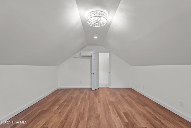 108 NW 29th St, Oak Island, NC 28465 - additional living space featuring vaulted ceiling, light wood-type flooring, and an AC wall unit