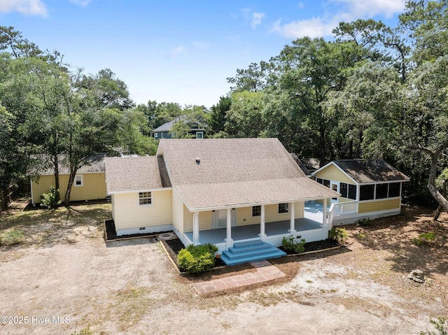 108 NW 29th St, Oak Island, NC 28465 - view of front of house with roof with shingles, a sunroom, driveway, a porch, and view of wooded area