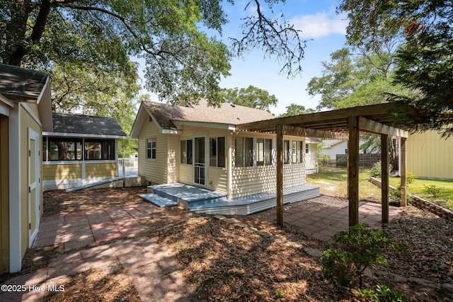 108 NW 29th St, Oak Island, NC 28465 - rear view of house with a sunroom, a patio, and roof with shingles