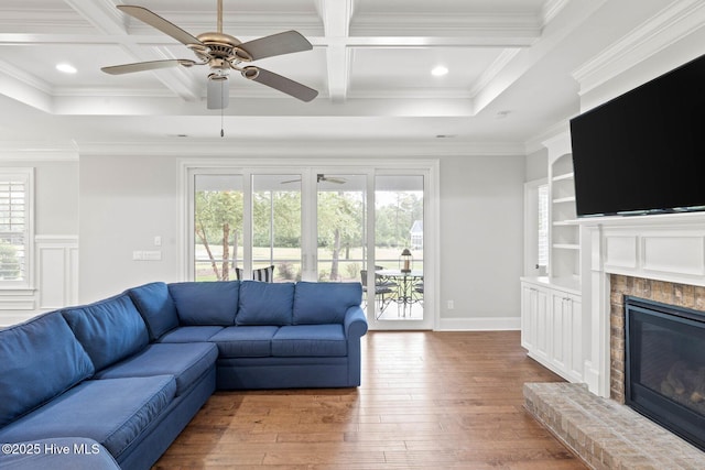 9385 Fallen Pear Ln NE, Leland, NC 28451 - living room featuring hardwood / wood-style floors, coffered ceiling, ceiling fan, a glass covered fireplace, and beamed ceiling