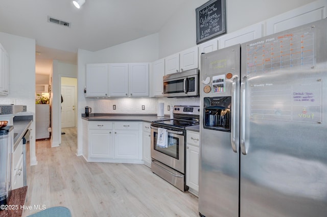 660 Pine Branches Cir SE, Leland, NC 28451 - kitchen featuring appliances with stainless steel finishes, tasteful backsplash, white cabinetry, lofted ceiling, and light wood-style floors