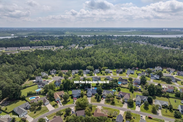 660 Pine Branches Cir SE, Leland, NC 28451 - aerial perspective of suburban area with a nearby body of water and a heavily wooded area