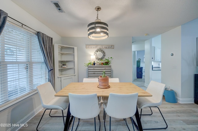 660 Pine Branches Cir SE, Leland, NC 28451 - dining space with light wood finished floors, a chandelier, and a textured ceiling