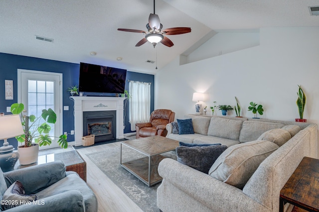 660 Pine Branches Cir SE, Leland, NC 28451 - living area featuring wood finished floors, a ceiling fan, vaulted ceiling, and a fireplace with flush hearth