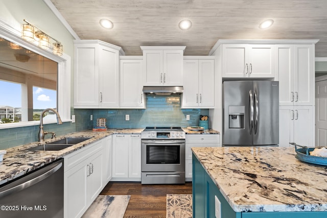6626 W Beach Dr, Oak Island, NC 28465 - kitchen featuring appliances with stainless steel finishes, under cabinet range hood, recessed lighting, white cabinets, and dark wood finished floors