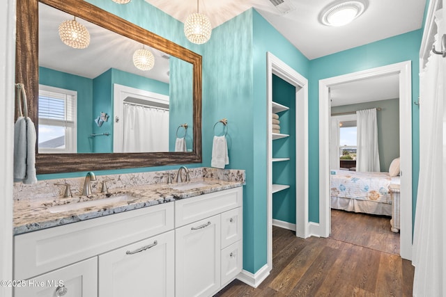 6626 W Beach Dr, Oak Island, NC 28465 - full bath featuring wood finished floors, double vanity, and connected bathroom