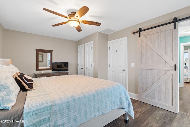 6626 W Beach Dr, Oak Island, NC 28465 - bedroom featuring a barn door, wood finished floors, and a ceiling fan