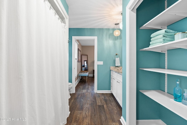 6626 W Beach Dr, Oak Island, NC 28465 - hallway featuring dark wood-type flooring and baseboards