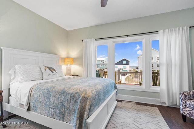 6626 W Beach Dr, Oak Island, NC 28465 - bedroom with multiple windows, dark wood finished floors, and ceiling fan