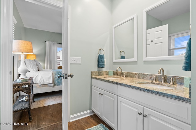 6626 W Beach Dr, Oak Island, NC 28465 - bathroom featuring double vanity, wood finished floors, and ensuite bath