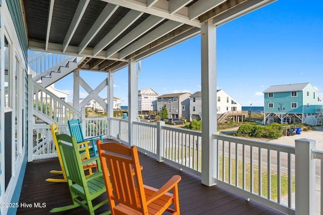 6626 W Beach Dr, Oak Island, NC 28465 - wooden porch featuring stairs and a residential view
