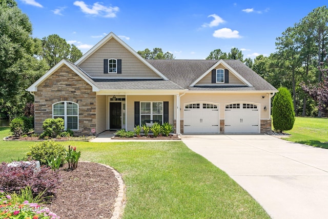3710 Calla Lilly Ct, Southport, NC 28461 - craftsman house with stone siding, an attached garage, a shingled roof, and a front lawn