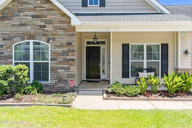 3710 Calla Lilly Ct, Southport, NC 28461 - doorway to property with a shingled roof, stone siding, and covered porch