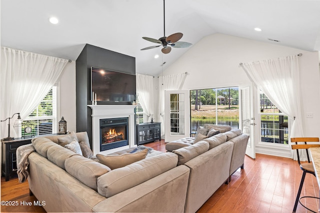 3710 Calla Lilly Ct, Southport, NC 28461 - living area featuring ceiling fan, high vaulted ceiling, a glass covered fireplace, plenty of natural light, and wood finished floors