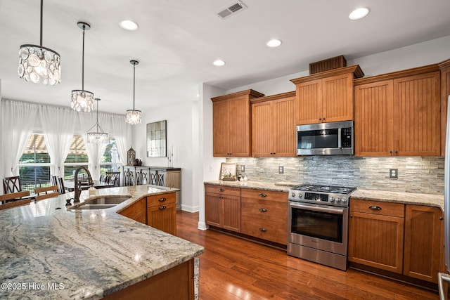 3710 Calla Lilly Ct, Southport, NC 28461 - kitchen with appliances with stainless steel finishes, decorative backsplash, brown cabinets, and recessed lighting