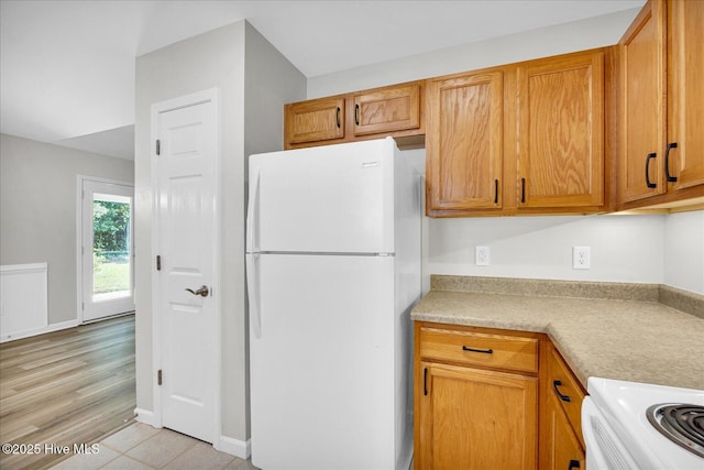 111 Yaupon Ct, Hampstead, NC 28443 - kitchen featuring freestanding refrigerator, light countertops, range, and brown cabinets