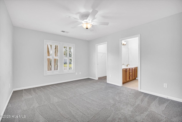 111 Yaupon Ct, Hampstead, NC 28443 - unfurnished bedroom featuring light colored carpet, a walk in closet, a closet, and a ceiling fan