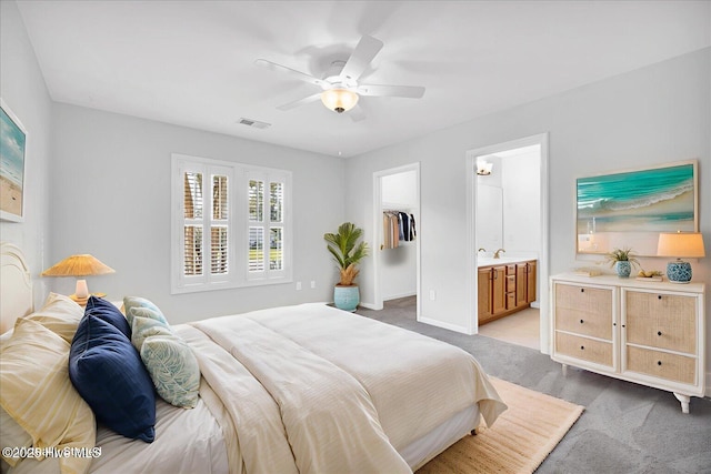 111 Yaupon Ct, Hampstead, NC 28443 - bedroom with light colored carpet, a spacious closet, ceiling fan, ensuite bath, and a closet