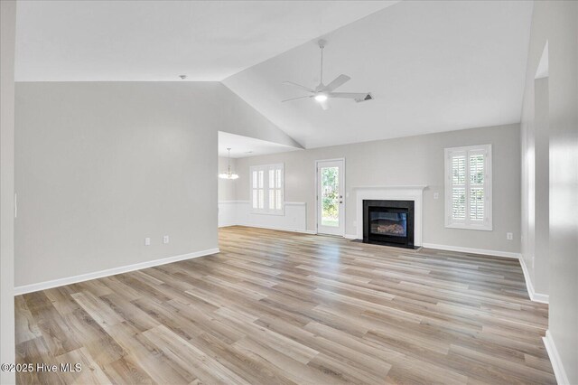 111 Yaupon Ct, Hampstead, NC 28443 - unfurnished living room with healthy amount of natural light, ceiling fan, a fireplace with flush hearth, a chandelier, and high vaulted ceiling
