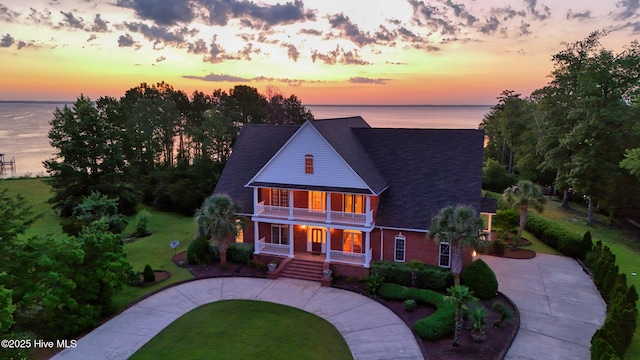240 Drake Lndg, New Bern, NC 28560 - view of front facade featuring covered porch, a balcony, a front yard, roof with shingles, and a water view