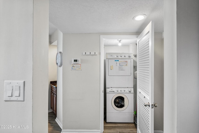 2000 New River Inlet Rd Unit 3513, North Topsail Beach, NC 28460 - washroom with stacked washing machine and dryer, a textured ceiling, and wood finished floors