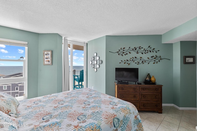 2000 New River Inlet Rd Unit 3513, North Topsail Beach, NC 28460 - bedroom with access to exterior, multiple windows, tile patterned floors, and a textured ceiling