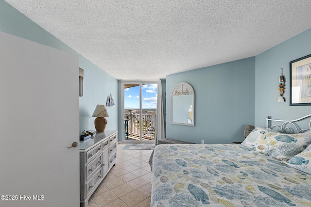 2000 New River Inlet Rd Unit 3513, North Topsail Beach, NC 28460 - bedroom featuring access to exterior, light tile patterned floors, a textured ceiling, and expansive windows